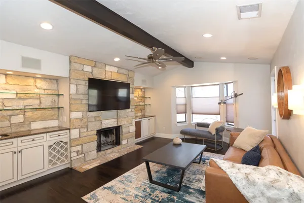a living room with furniture a flat screen tv and a fireplace