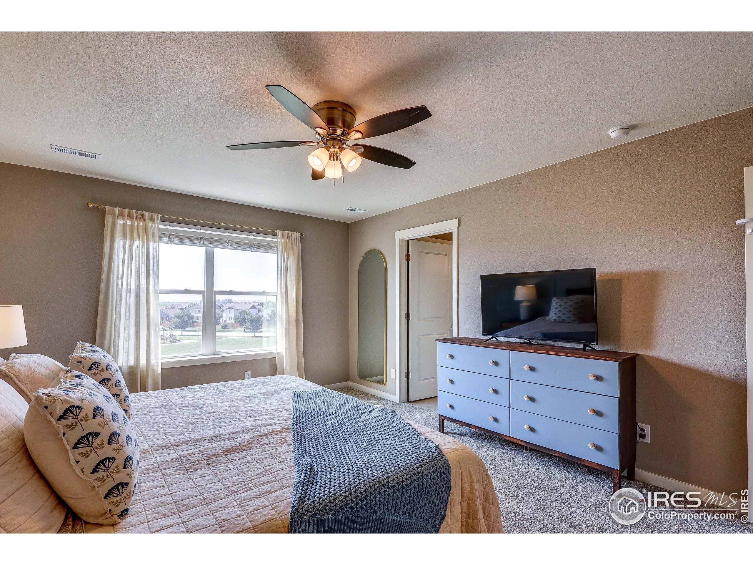 1335 Copeland Falls Road Severance, CO 80550 - Photo 26 of 40 a bedroom with a bed and a flat screen tv