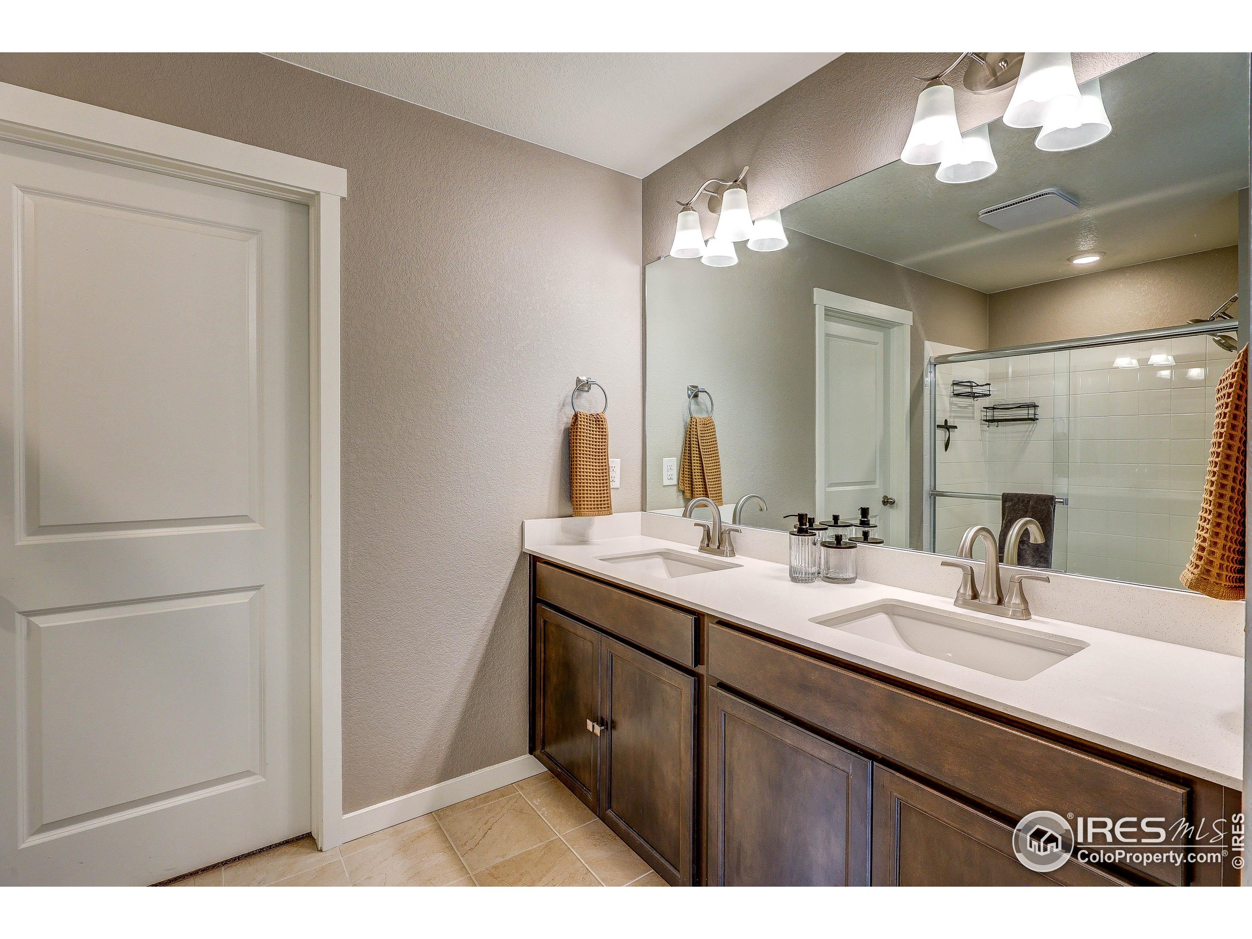 1335 Copeland Falls Road Severance, CO 80550 - Photo 28 of 40 a bathroom with a double vanity sink and a mirror