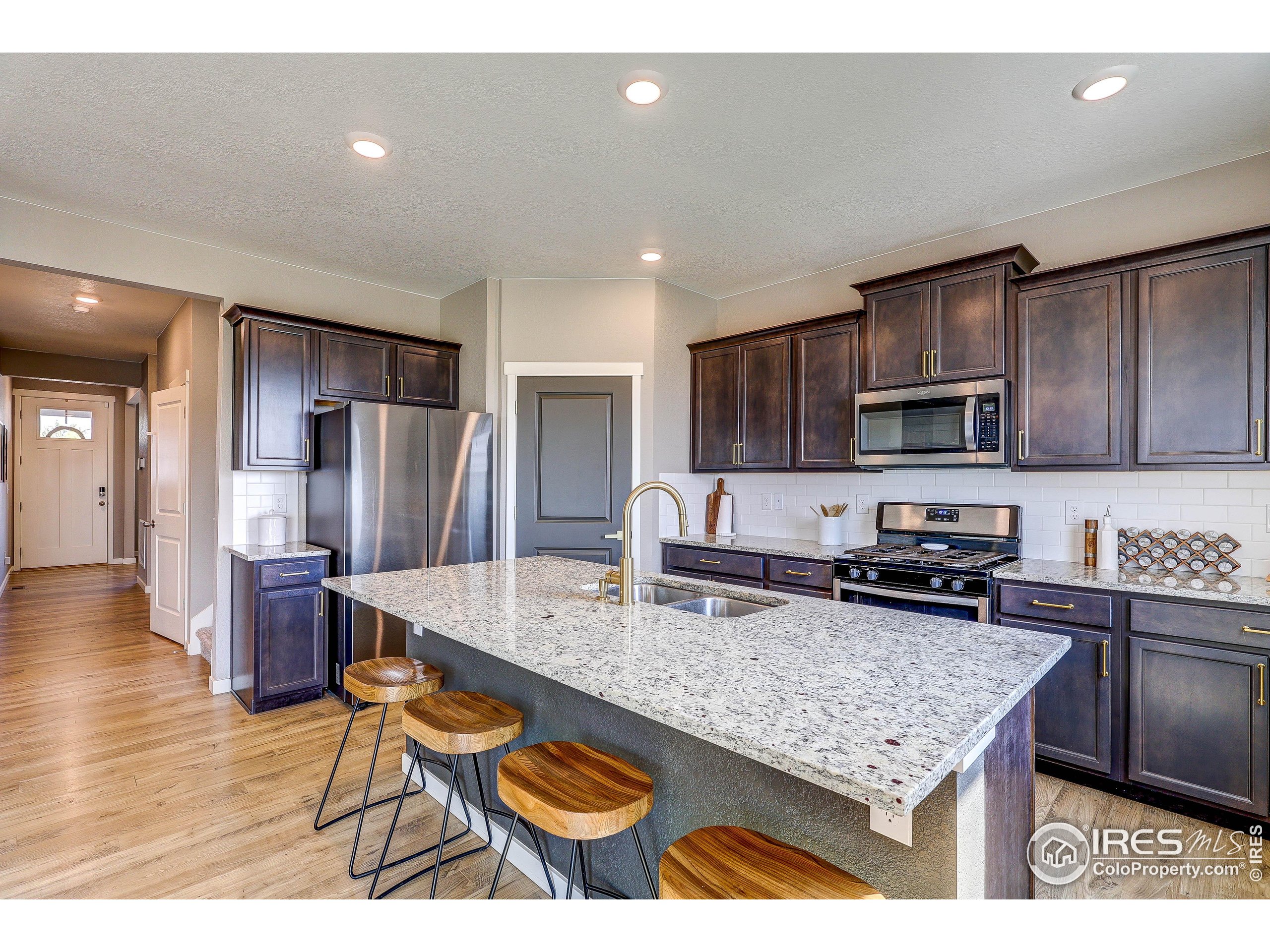 1335 Copeland Falls Road Severance, CO 80550 - Photo 7 of 40 a kitchen with stainless steel appliances granite countertop a sink refrigerator and cabinets
