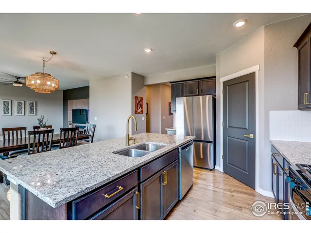 a kitchen with stainless steel appliances granite countertop a kitchen island a stove and a sink