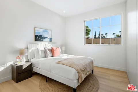 a bedroom with a bed lamp and a window