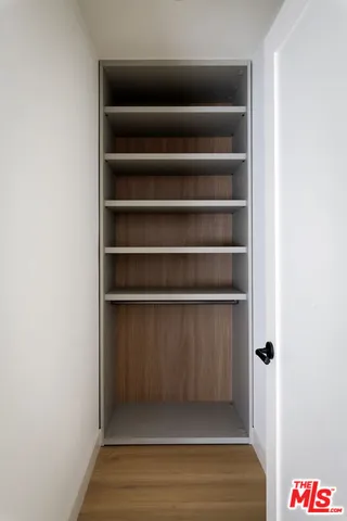 a view of a dining room and livingroom with furniture wooden floor a rug a fireplace and a chandelier