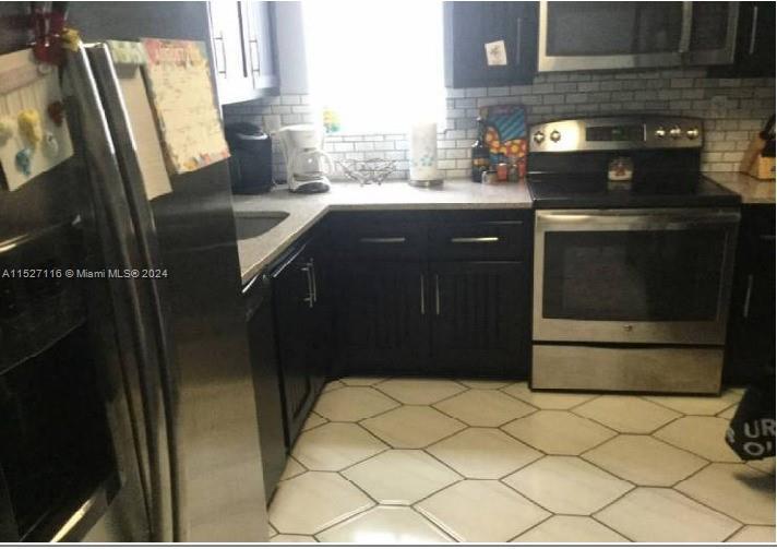 1665 Bay Road, Unit 425 Miami Beach, FL 33139 - Photo 27 of 29 a kitchen with granite countertop a refrigerator a stove a sink and dishwasher