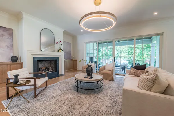 a living room with furniture a fireplace and a large window