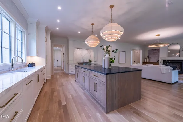 a large kitchen with kitchen island granite countertop a large center island attached withe living room