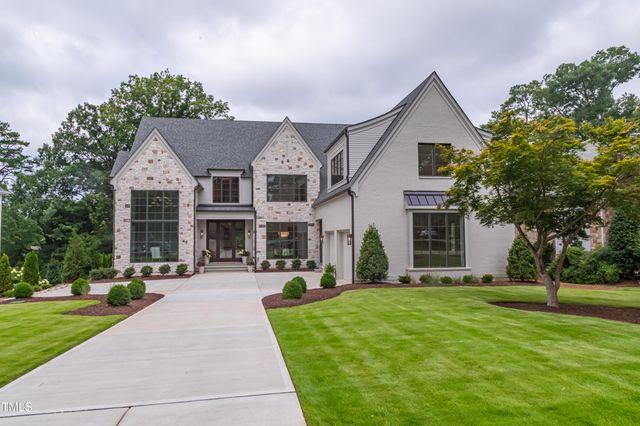 a front view of a house with a yard and trees