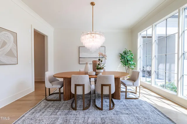 a dining room with furniture a chandelier and wooden floor