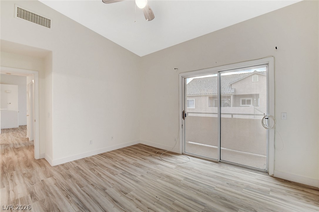 2052 Quarry Ridge Street, Unit 201 Las Vegas, NV 89117 - Photo 16 of 25 A private balcony extends from this airy bedroom with resilient wood flooring.