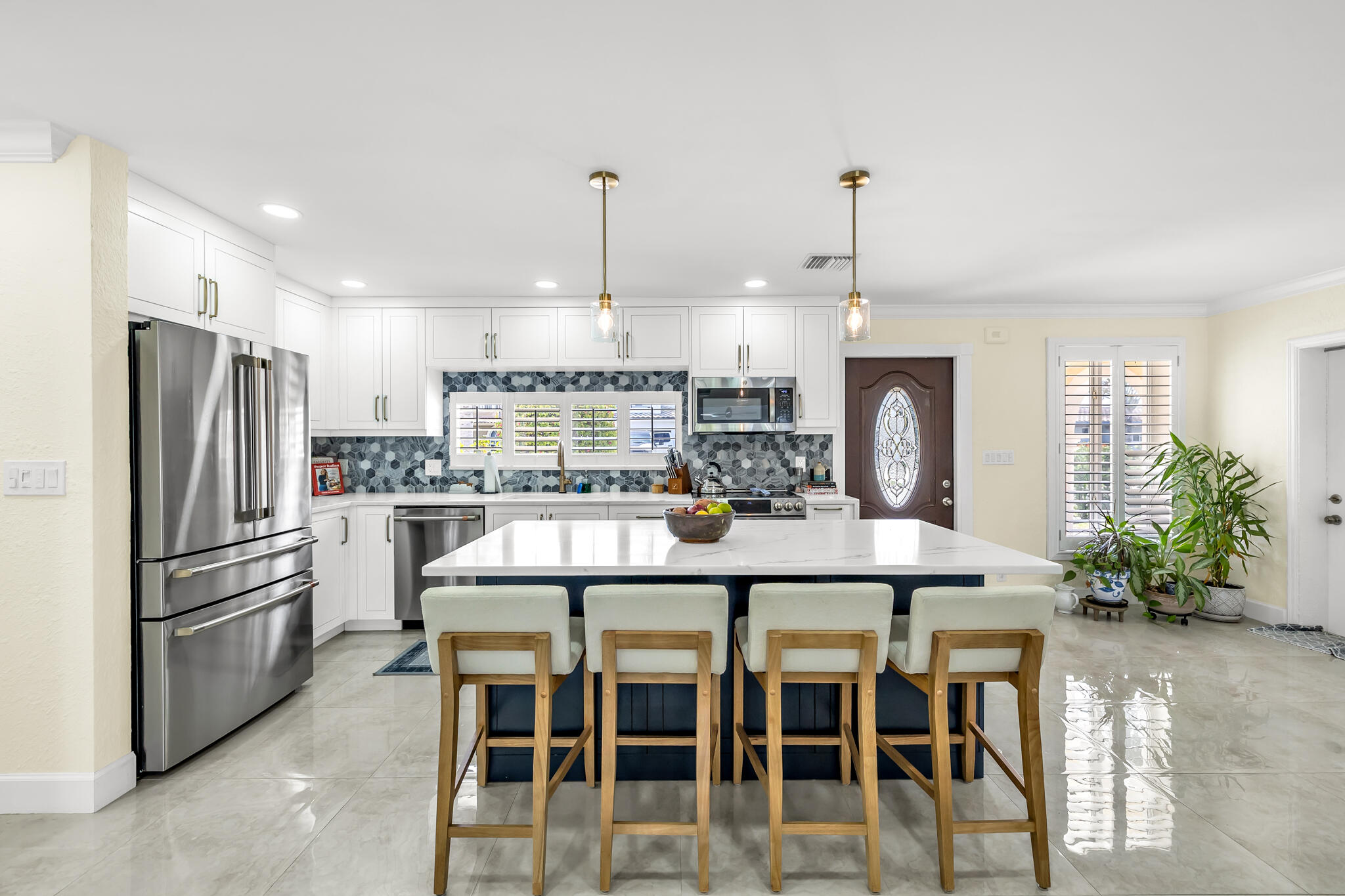4920 Northeast 28th Avenue Lighthouse Point, FL 33064 - Photo 14 of 38 a kitchen with stainless steel appliances kitchen island granite countertop a dining table chairs and refrigerator