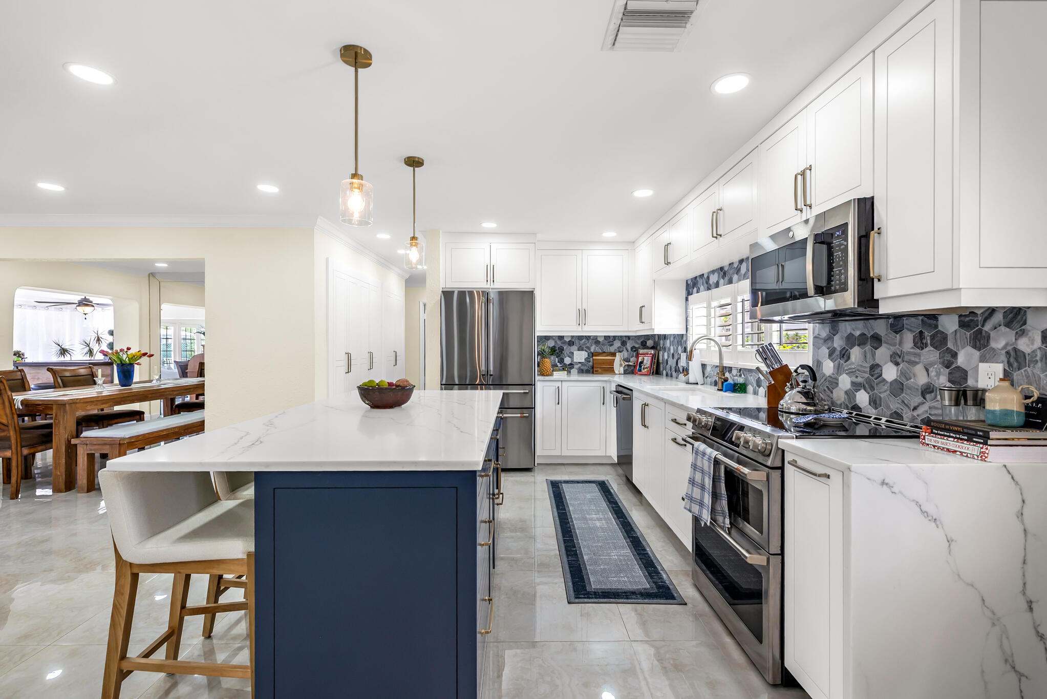 4920 Northeast 28th Avenue Lighthouse Point, FL 33064 - Photo 17 of 38 a kitchen with stainless steel appliances kitchen island a sink stove and cabinets