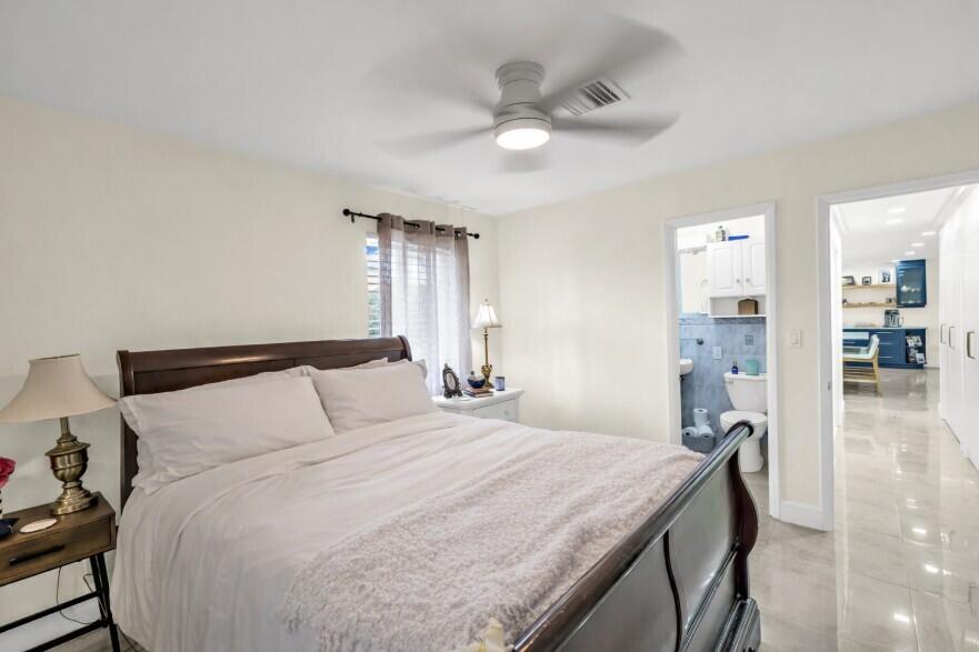 4920 Northeast 28th Avenue Lighthouse Point, FL 33064 - Photo 29 of 38 a bedroom with a bed and a chandelier