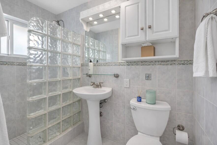 4920 Northeast 28th Avenue Lighthouse Point, FL 33064 - Photo 30 of 38 a bathroom with a sink a toilet and shower