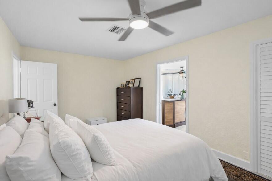 4920 Northeast 28th Avenue Lighthouse Point, FL 33064 - Photo 31 of 38 a bedroom with a large bed and a chandelier