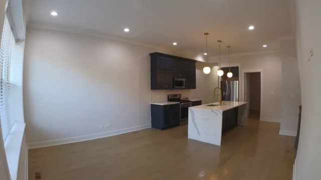 a large kitchen with a refrigerator and a sink