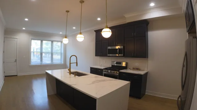 a kitchen with kitchen island a sink stainless steel appliances and cabinets