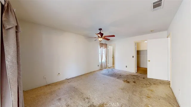 a view of a room with a ceiling fan and entryway
