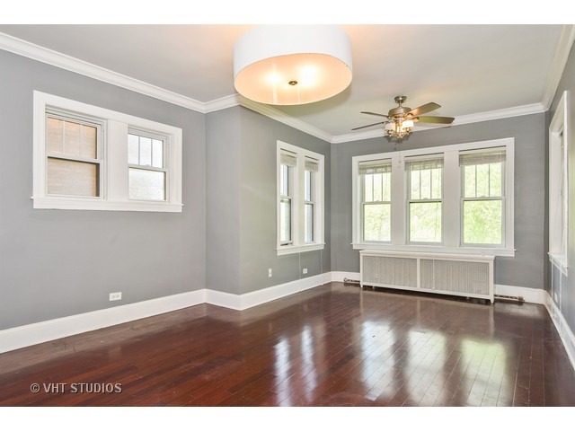 647 West Sheridan Road, Unit 4E Chicago, IL 60613 - Photo 2 of 10 an empty room with wooden floor and windows