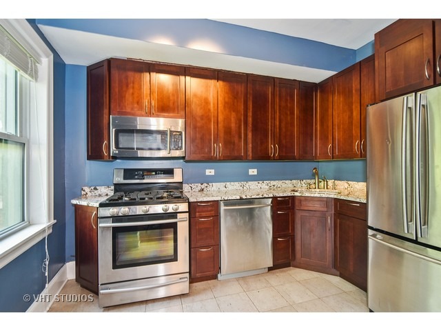 647 West Sheridan Road, Unit 4E Chicago, IL 60613 - Photo 4 of 10 a kitchen with stainless steel appliances granite countertop a stove a refrigerator and a microwave