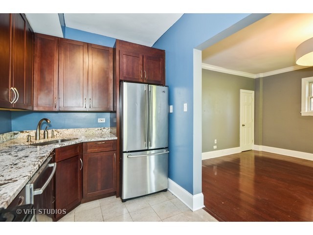 647 West Sheridan Road, Unit 4E Chicago, IL 60613 - Photo 10 of 10 a kitchen with kitchen island wooden cabinets and appliances