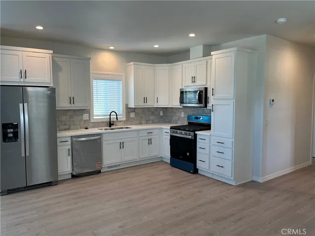 a kitchen with white cabinets and stainless steel appliances