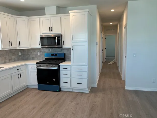 a kitchen with white cabinets and stainless steel appliances