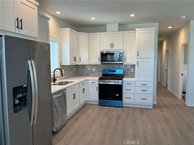 a kitchen with stainless steel appliances a refrigerator stove and sink
