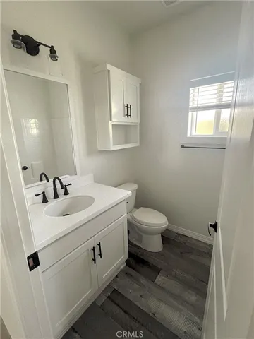 a bathroom with a sink mirror vanity and toilet