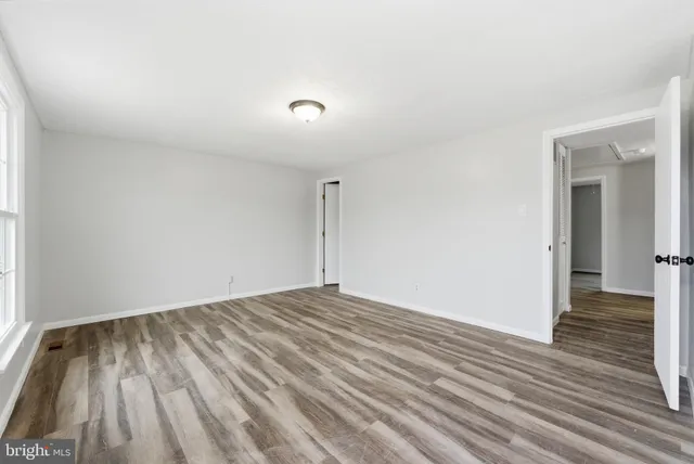 a view of an empty room with wooden floor