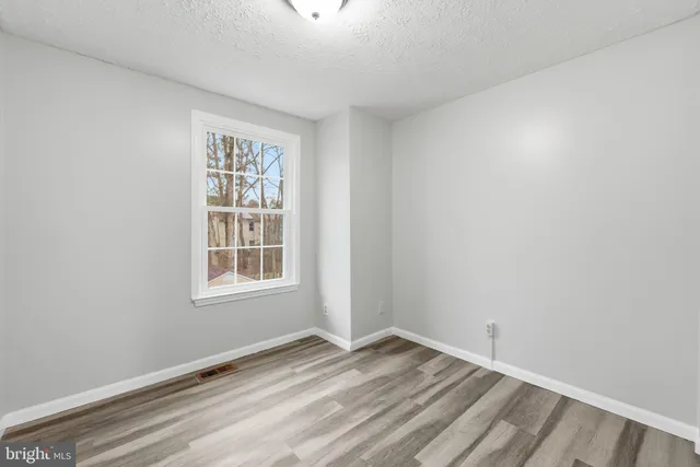 a view of a hallway with wooden floor and closet