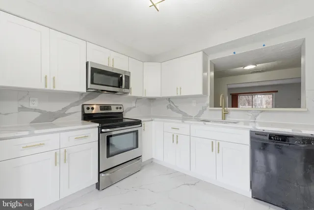 a kitchen with granite countertop a sink and stainless steel appliances