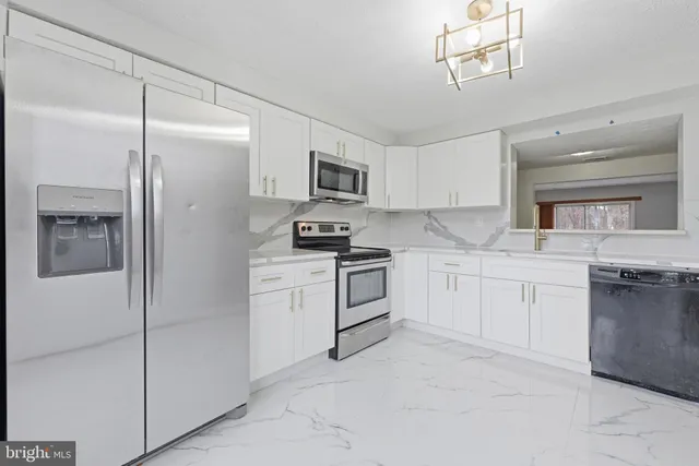 a kitchen with white cabinets and stainless steel appliances