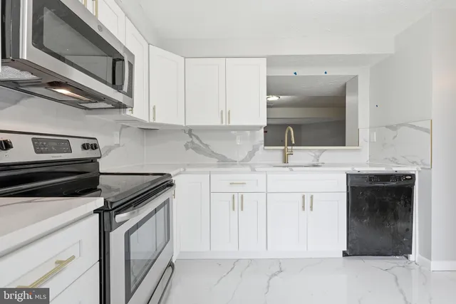 a kitchen with granite countertop white cabinets and stainless steel appliances