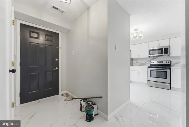 a kitchen with a refrigerator and stove top oven