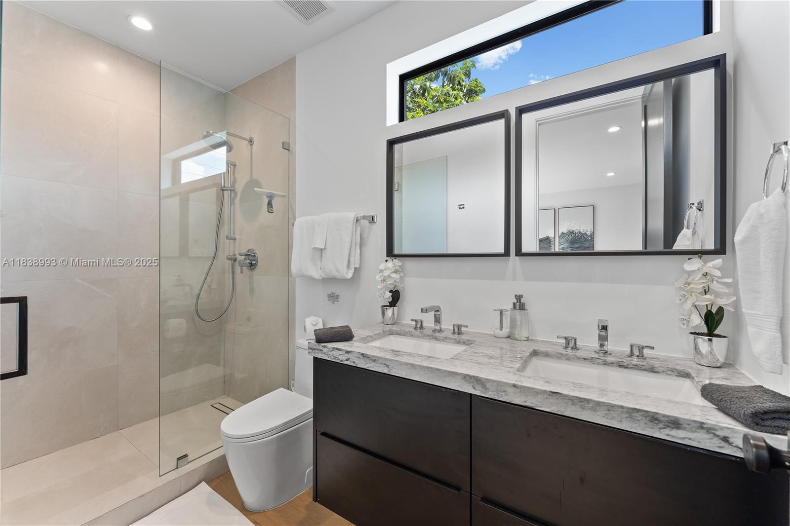 58 Northwest 52nd Street, Unit 58 Miami, FL 33127 - Photo 12 of 21 a bathroom with a granite countertop sink mirror and a toilet
