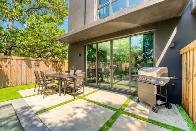 a view of a patio with table and chairs next to a yard