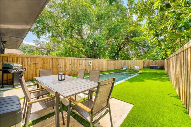 a view of a backyard with table and chairs and wooden fence
