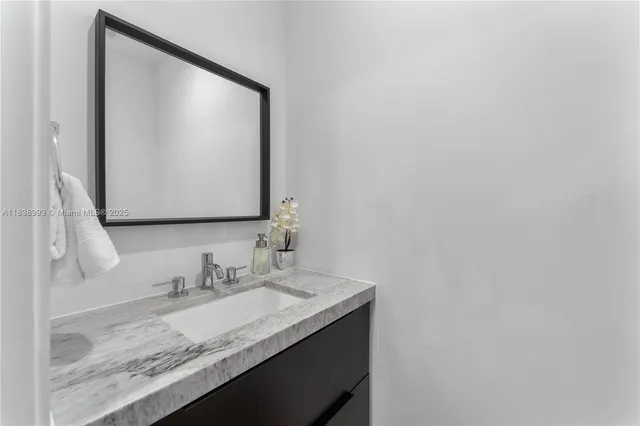 a bathroom with a granite countertop sink and a mirror