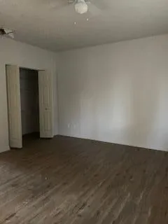 an empty room with wooden floor and closet