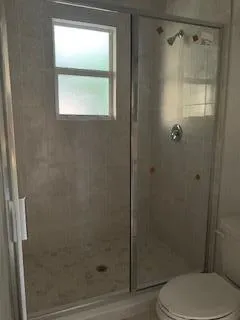 a bathroom with a toilet and a shower