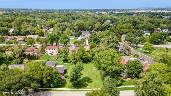 an aerial view of residential house with outdoor space and trees all around