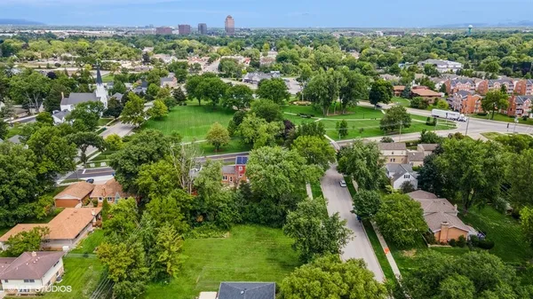 an aerial view of residential house with outdoor space and trees all around