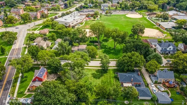 an aerial view of residential houses with outdoor space and street view