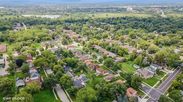an aerial view of a houses with a lush green hillside