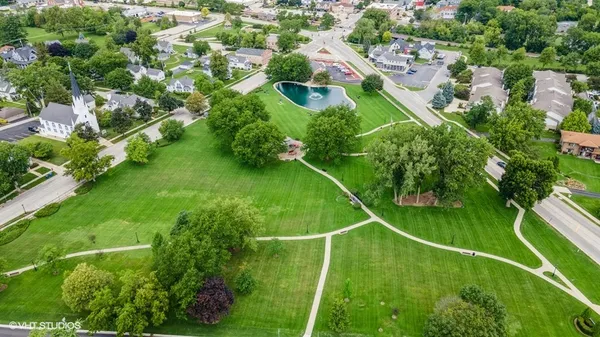 an aerial view of residential houses with outdoor space and trees