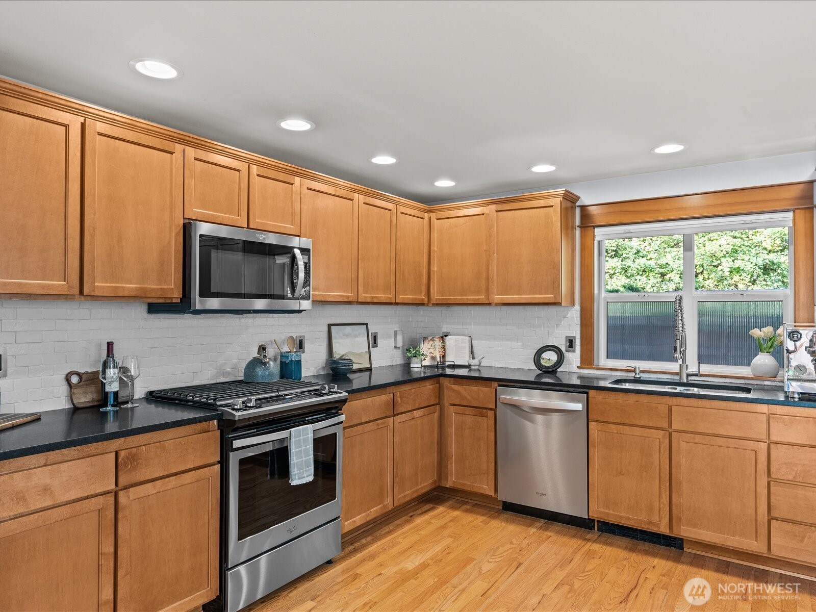 3018 Southwest Hinds Street Seattle, WA 98126 - Photo 11 of 27 a kitchen with stainless steel appliances granite countertop a sink a stove a microwave a refrigerator and cabinets