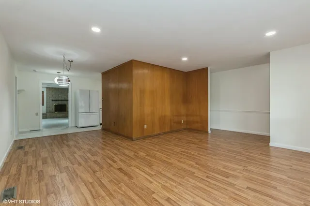 a view of empty room with wooden floor