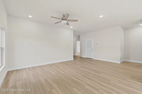 a view of an empty room with wooden floor