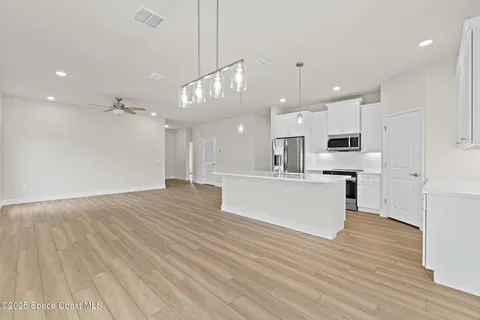 a view of a room with wooden floor and a bathroom