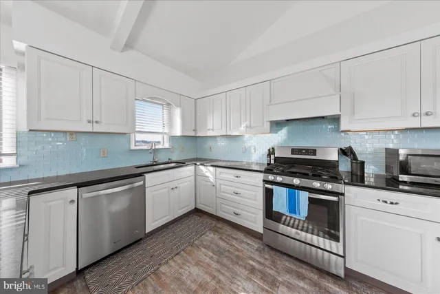 a kitchen with granite countertop white cabinets and white appliances